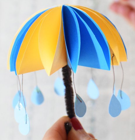 Paper umbrella with little paper raindrops dangling from its ends