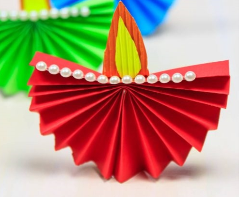 A paper diya made of colored paper and accessories 