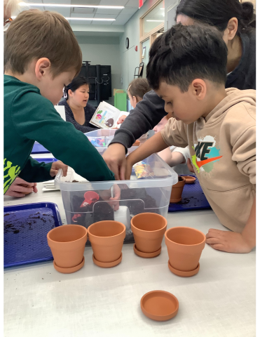 Children scooping potting soil into small planter pots.
