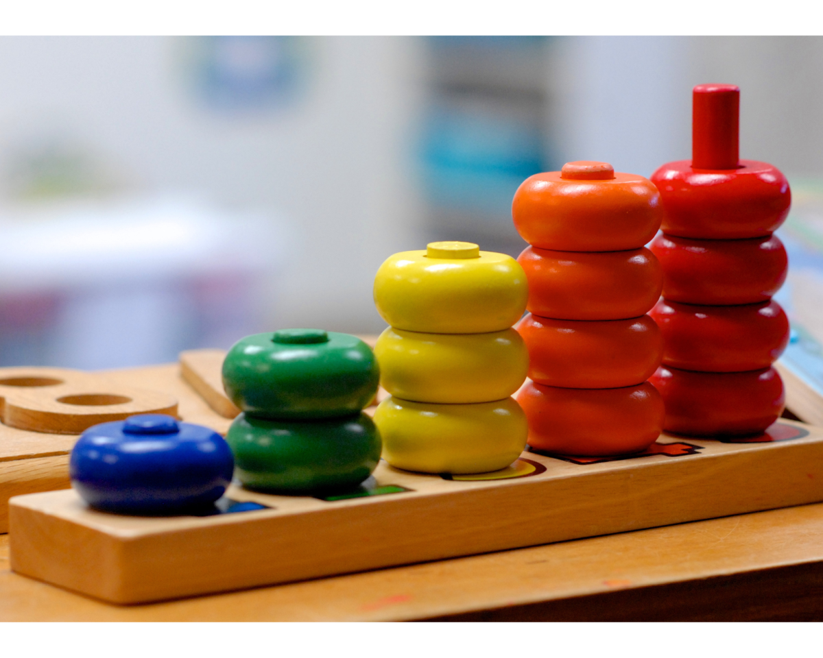 Counting toy with colorful round wooden pieces on pegs, from one to five.