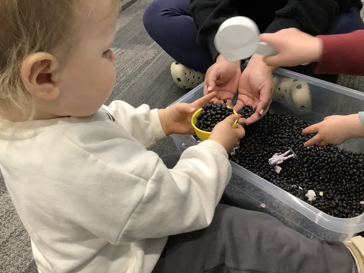 Child playing with a space sensory bin.